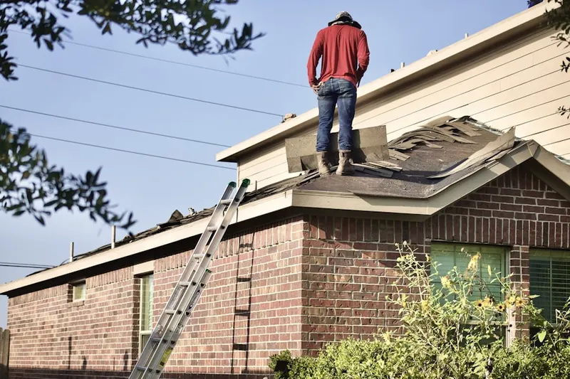 Professional roofer working on a residential roof in Demarest